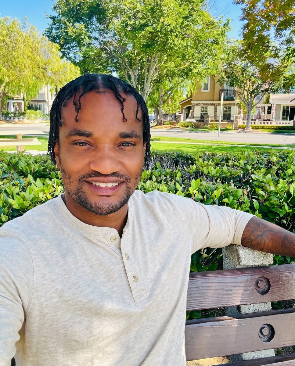 Randy Wynglass, LMFT — California and Florida-licensed Marriage and Family Therapist, smiling and seated outdoors on a wooden bench in a warm afternoon setting.